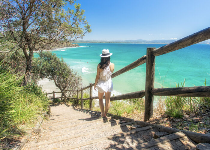 woman wlaking down steps to the beach